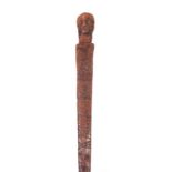 A 19TH CENTURY SOUTH ISLANDS CARVED WALKING STICK with mask head handle and chip carved stem 83cm