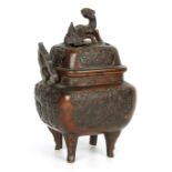 AN EARLY CHINESE BRONZE LIDDED CENSER with dragon finial above embossed panels decorated with leaf
