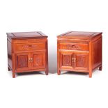 A PAIR OF MID 20TH CENTURY CHINESE HARDWOOD BEDSIDE CABINETS with panelled tops above frieze drawers