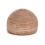 A 19TH CENTURY TREEN BEEHIVE SHAPED DOORSTOP with weighted lead base 9cm high 13cm diameter