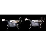 A PAIR OF GEORGE VI SILVER SAUCEBOATS the plain bodies on splay feet with scalloped rims and