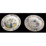 TWO 18TH CENTURY DELFT POLYCHROME PLATES with flower spray and leaf decoration depicting a bird