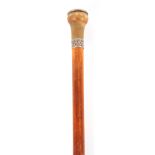 A 19TH CENTURY MALACCA CANE WALKING STICK WITH A RHINO HORN HANDLE having a dice game inset to the