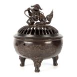 A CHINESE BRONZE CENSER with pierced cover surmounted by a Foo dog with ball finial, the body with