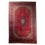 A LARGE MULTI COLOURED MIDDLE EASTERN CARPET with flower head medallion centre. 405cm long 269cm