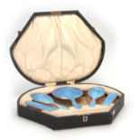 A GEORGE V CASED SILVER AND BLUE ENAMEL FIVE PIECE LADIES DRESSING TABLE SET comprising a Hand