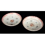 A PAIR OF 18TH CENTURY CHINESE EXPORT FAMILLE ROSE LARGE STRAINING DISHES ON THREE PEG FEET