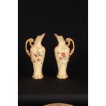 A STYLISH PAIR OF ROYAL WORCESTER BLUSHED IVORY AND RELIEF GILT MOULDED EWERS the tapered shouldered