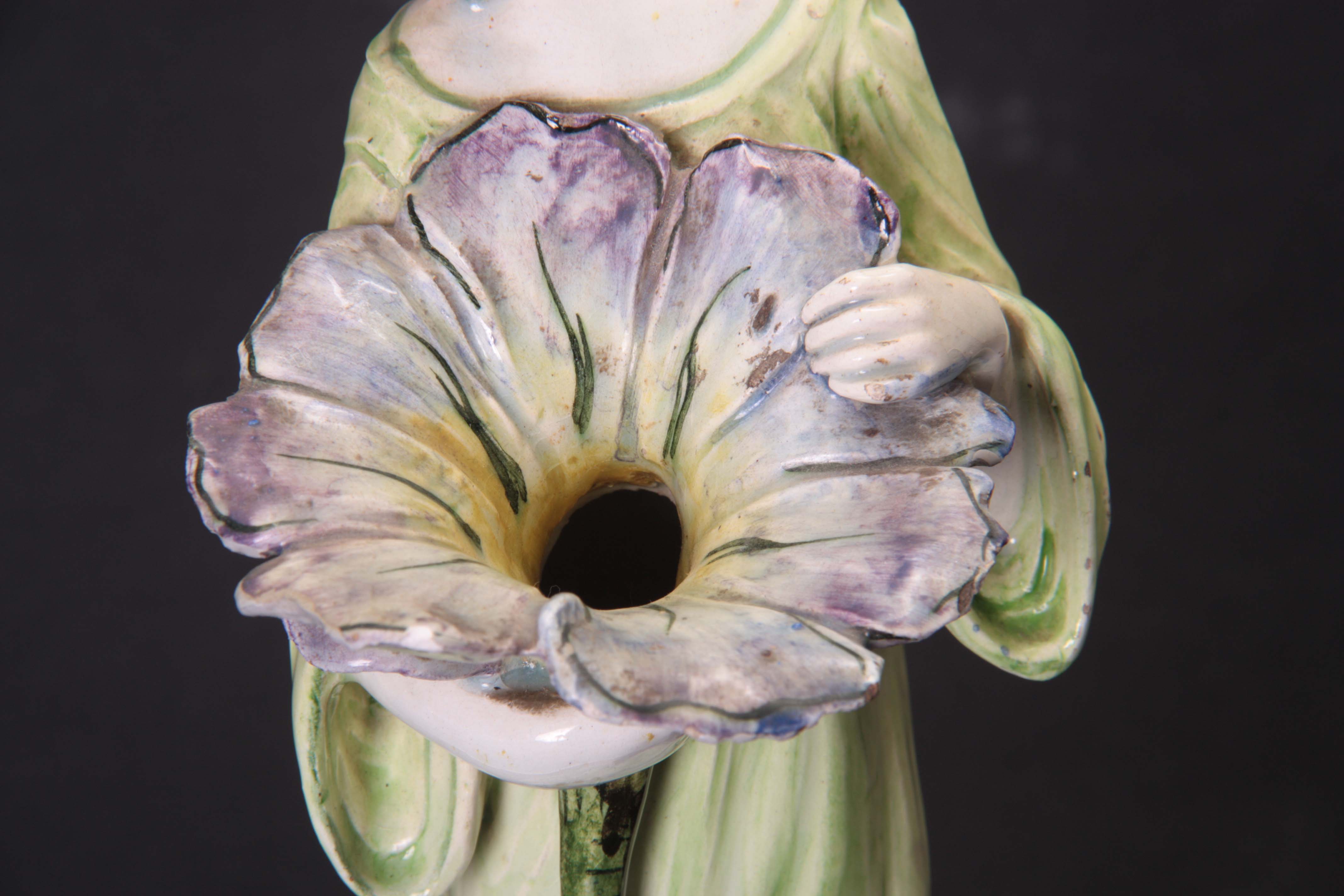 AN ART NOUVEAU GLAZED POTTERY FIGURE modelled as a standing lady clutching a flower head with hollow - Image 2 of 5