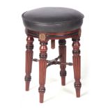 A REGENCY MAHOGANY AND EBONISED REVOLVING PIANO STOOL with black leather seat on turned fluted