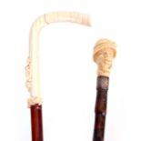 TWO LATE 19TH CENTURY IVORY HANDLED WALKING CANES the first modelled as a carved African man wearing