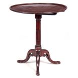 A GEORGE III MAHOGANY TILT TOP OCCASIONAL TABLE with a dished circular top having a carved border