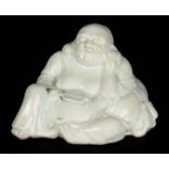 A CHINESE BLANC DE CHINE FIGURE OF BUDDHA with glazed finish 14cm high, 22.5cm wide