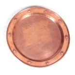 AN ART NOUVEAU PATINATED COPPER CHARGER with planished finish and relief work heart design