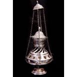 AN ORNATE PIERCED AND EMBOSSED SILVER METAL INCENSE BURNER of footed baluster form with chain
