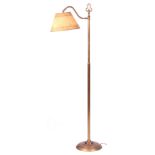 A 20TH CENTURY BRASS STANDARD LAMP with shaped top and shade, on a circular base 149cm high