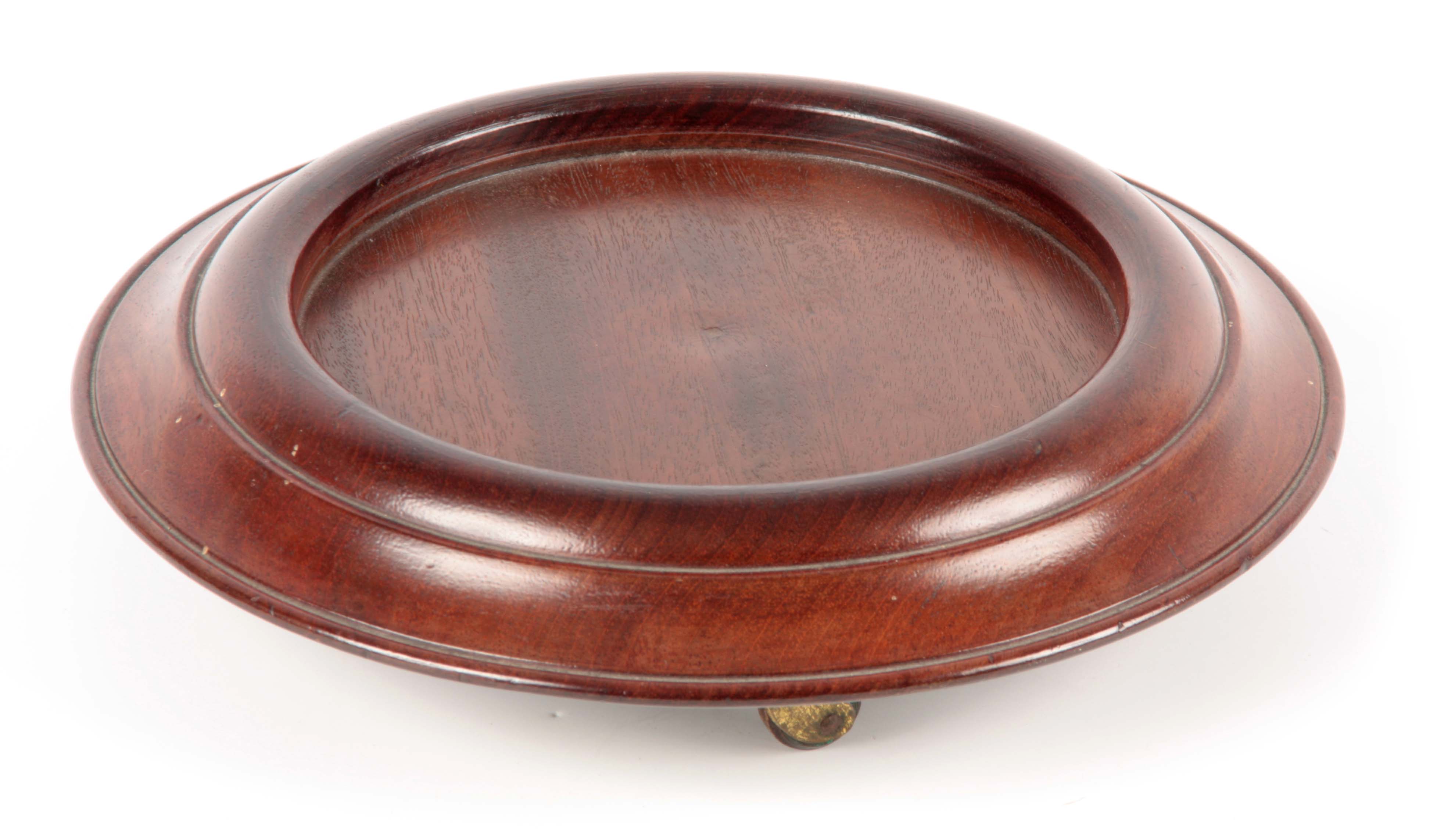 A GEORGE III MAHOGANY TABLE BOTTLE COASTER of circular form with moulded border, raised on revolving