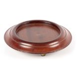 A GEORGE III MAHOGANY TABLE BOTTLE COASTER of circular form with moulded border, raised on revolving