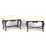 A PAIR OF EARLY 18TH CENTURY STAINED WALNUT STOOLS with cabriole legs joined by shaped seat rails