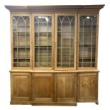 A 19TH CENTURY PINE BREAKFRONT BOOKCASE with moulded cornice above four astragal glazed hinged doors