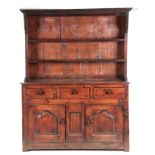 AN EARLY 18TH CENTURY OAK WELSH DRESSER AND RACK with canopy moulded top fitted with two shelves and