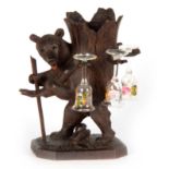 A 19TH CENTURY CARVED BLACK FOREST DECANTER modelled as a bear carrying a tree stump on a