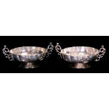 A PAIR OF LATE VICTORIAN ART NOUVEAU STYLE PEDESTAL SILVER DISHES WITH RAISED SCROLLWORK HANDLES the