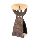 AN UNUSUAL ARTS AND CRAFTS STYLE BRONZED METAL PRICKET CANDLESTICK with panelled skirted base, broad