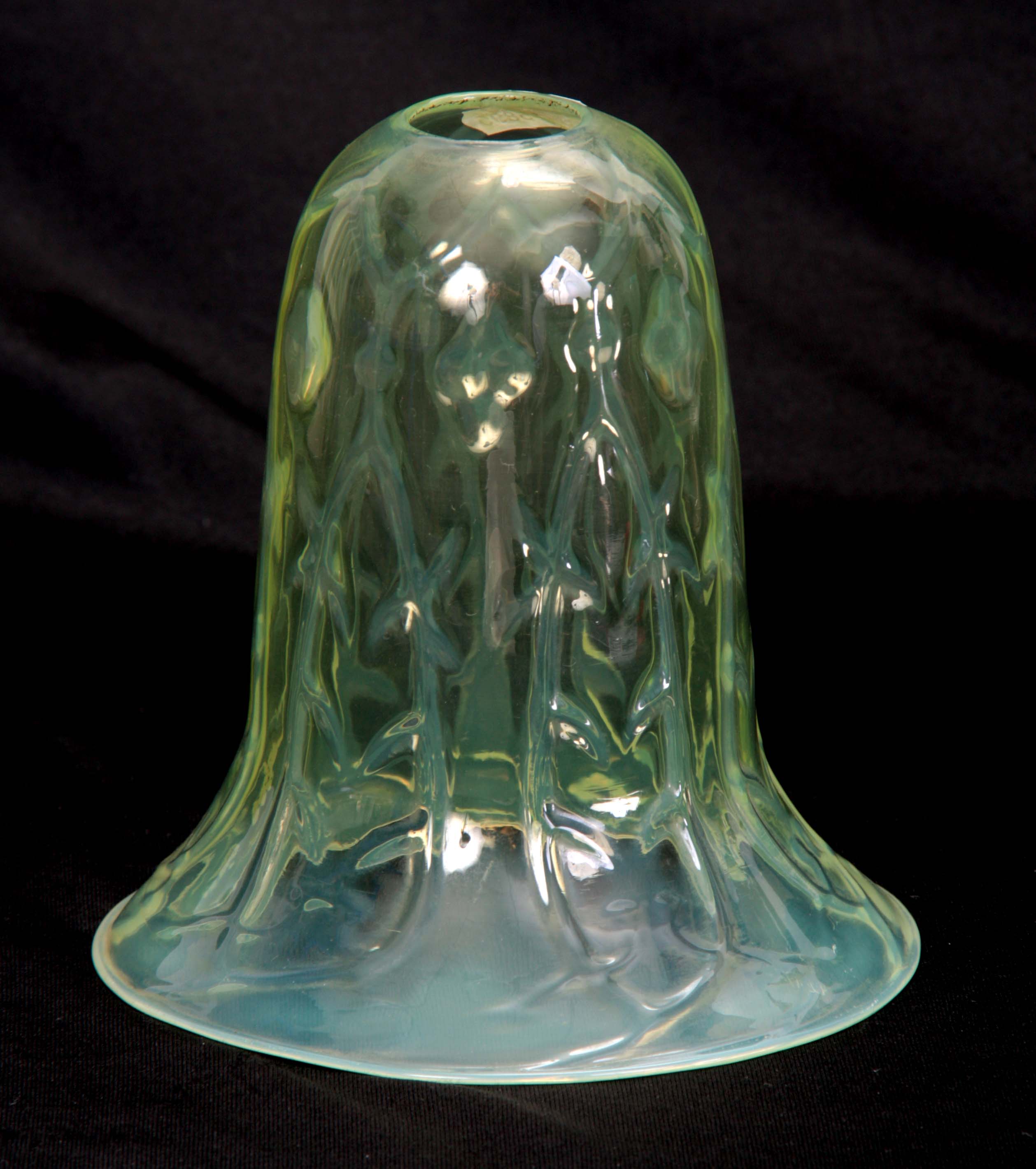 A 20TH CENTURY VASELINE GLASS HANGING SHADE of skirted form with relief moulded pronged leafwork