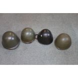 Four army steel helmets of WWII and later