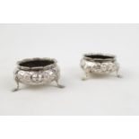 Pair of Mid Victorian Silver Floral ebossed Open salts supported on pad feet, By William Hunter,