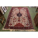 Red Ground Persian machine made rug with tassel ends 185 x 122cm