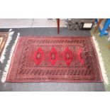 Small Red ground rug with tassel ends 135 x 80cm