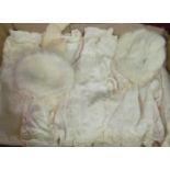 A collection of baby clothes including; long and short dresses, a hat, gloves et cetera and a