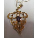 A gold and amethyst pendant on chain