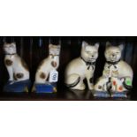 Two pairs of cat ornaments seated on cushions and two other pairs of cat ornaments