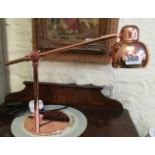 A copper anglepoise desk lamp.