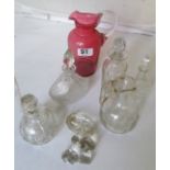 Five glass bottles and a cranberry glass jug