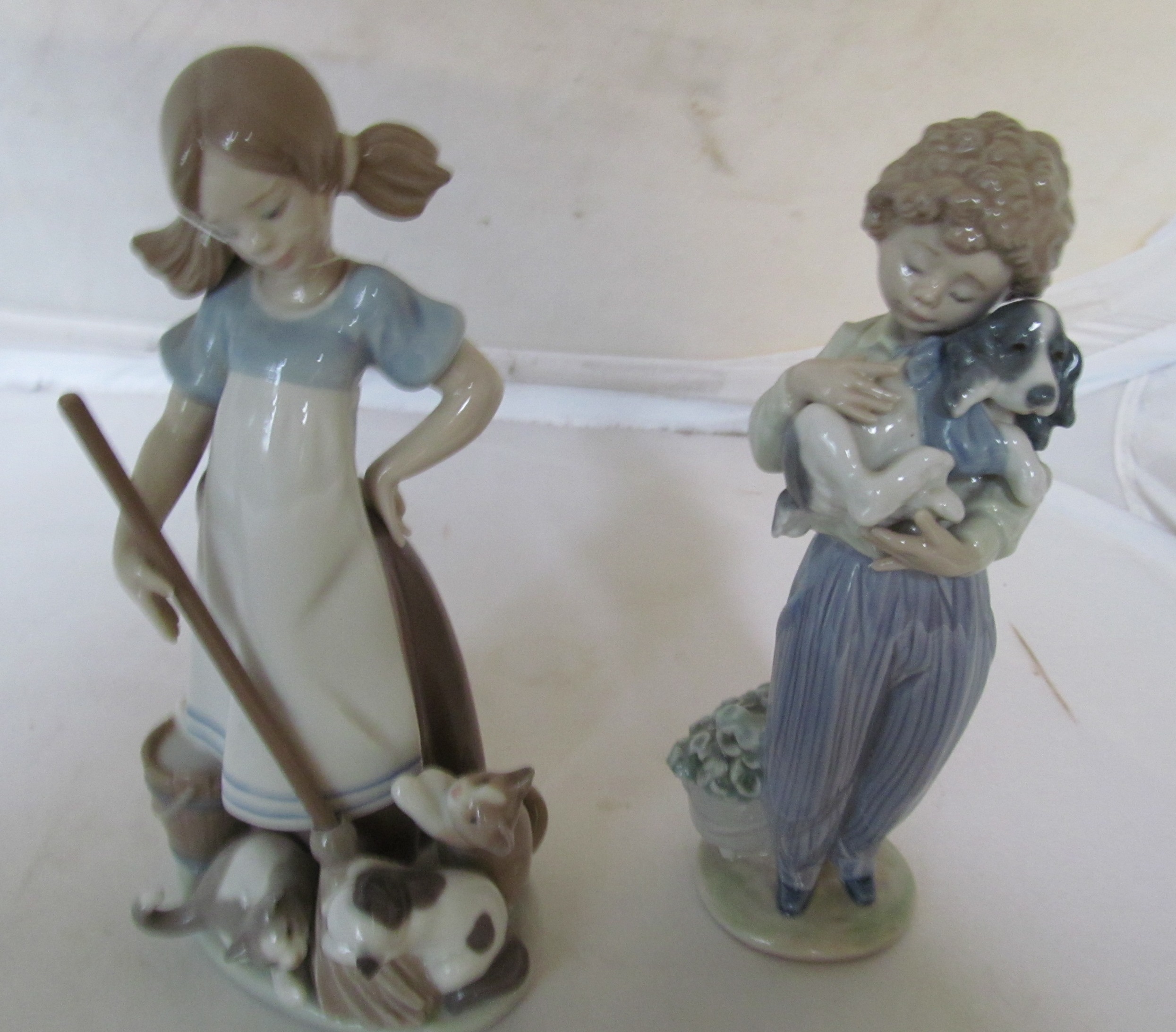 A Lladro girl with broom and kittens and a Lladro boy with dog