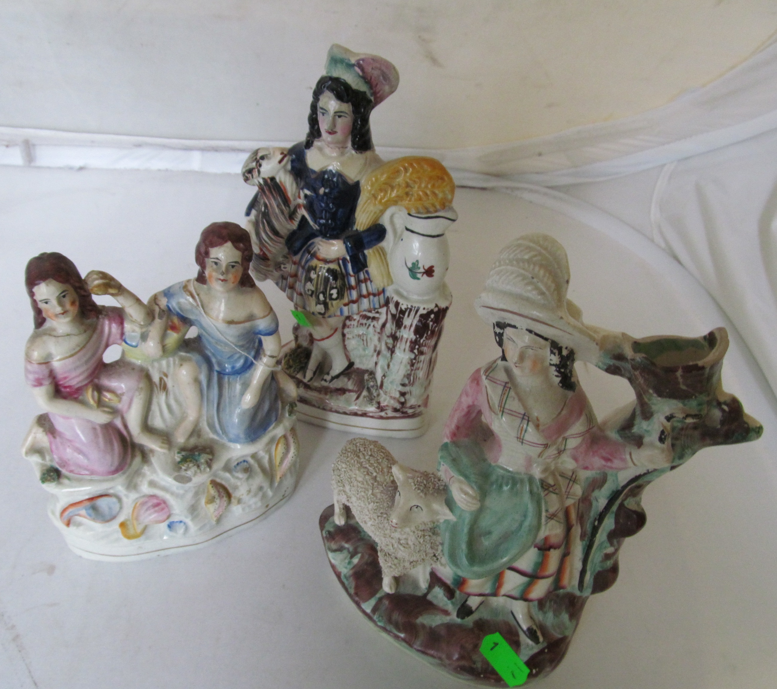 A Staffordshire flatback figure girl with sheep, another two girls on shell design base and