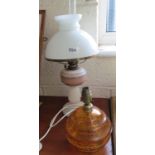 An opaque glass oil lamp and an amber glass table lamp