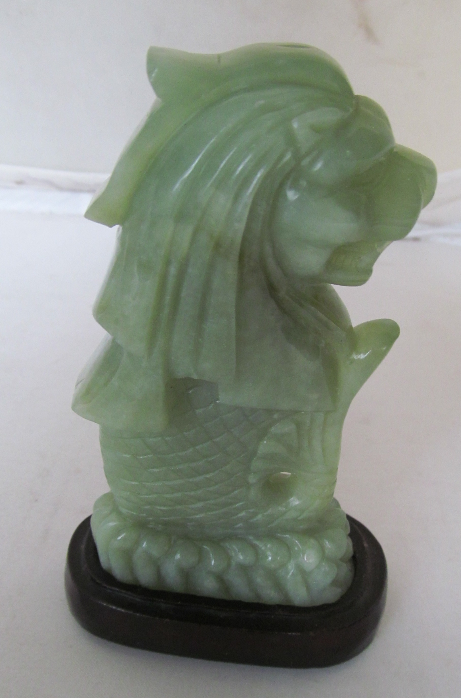 A jade Merlion on stand.