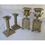 A pair of brass urn shaped vases on plinth bases and a pair of corinthian column candlesticks