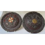 A pair of carved circular heraldic plaques