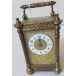 A 19th Century brass carriage clock with embossed floral face