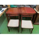 A retro teak extending dining table on tapered supports and four chairs