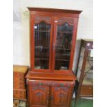 A carved Victorian bookcase, glazed doors above and cupboards under
