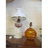 An opaque glass oil lamp and an amber glass table lamp