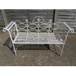 A small white metal garden bench