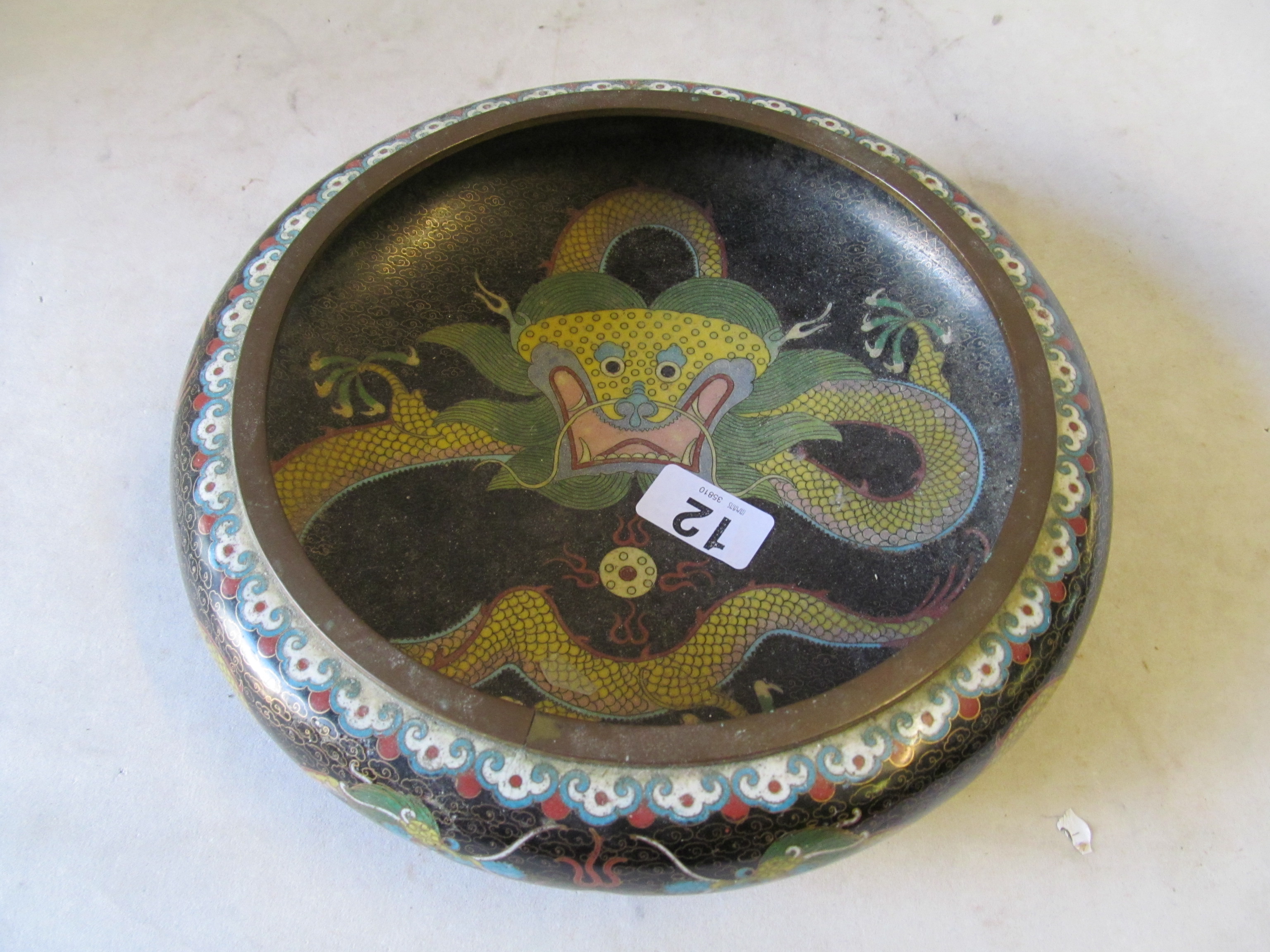 An early 20th Century cloisonné bowl dragon on a black background.